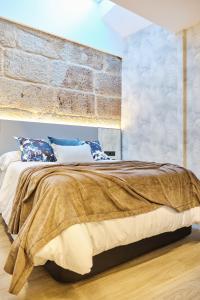 A bed or beds in a room at Apartamentos Pedreira Casa Historica Down Town