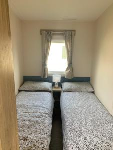 two beds in a small room with a window at Seton Sands Haven Holiday Village in Edinburgh