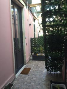 un pasillo de un edificio con una puerta y plantas en B&B Affittacamere Trigona, en Misterbianco