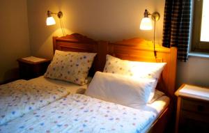 1 dormitorio con 1 cama con 2 almohadas y 2 luces en Ferienwohnung Ebner, en Kiefersfelden