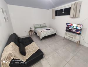 uma sala de estar com um sofá e uma televisão em Casa em Florianópolis em Florianópolis