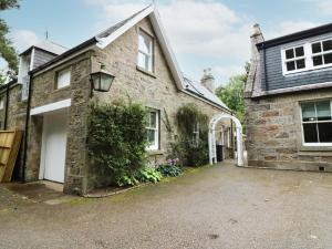 uma casa de pedra com uma garagem e uma entrada em Hayloft em Peterhead