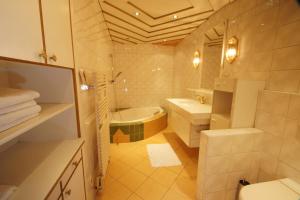 a bathroom with a tub and a toilet and a sink at Gasthof zur Post in Strasswalchen