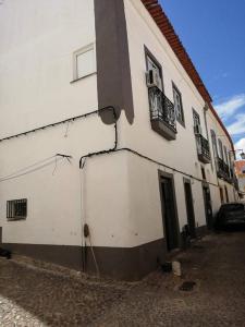 Biały budynek z ulicą obok niego w obiekcie Casa das Histórias w mieście Beja