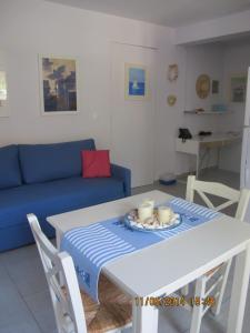 a living room with a table and a blue couch at Muses Studios Sami in Sami