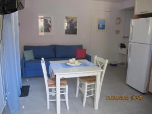 a living room with a table and a blue couch at Muses Studios Sami in Sami