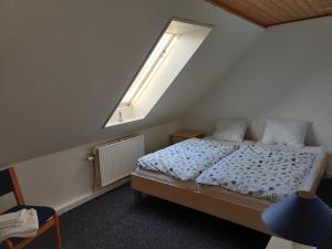 a bedroom with a large bed with a skylight at Købmandsgaardens B&B in Gedser