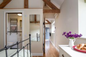 une cuisine avec un escalier et un vase de fleurs violettes dans l'établissement The Cow Shed, Kenilworth, Sleeps 2, à Kenilworth