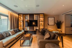 a living room with a couch and a tv at The Fellows House Mews in Cambridge