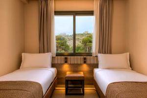 2 letti in una camera con finestra di Radisson Blu Residences Al Hoceima ad Al-Ḥoseyma Altre 37 foto