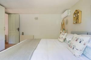 una camera da letto con un grande letto bianco con cuscini di Boutique Apartment Altea La Vella ad Altea