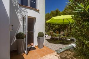 un patio con ombrellone, tavolo e sedie di Boutique Apartment Altea La Vella ad Altea