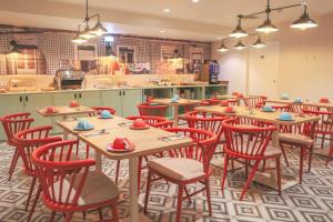 a restaurant with wooden tables and red chairs at Mouraria Lisboa Hotel in Lisbon