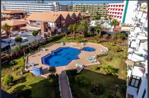 vista aerea su una grande piscina in città di Apartamento en Playa del Ingles CC Yumbo a Maspalomas