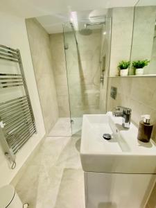 a white bathroom with a sink and a shower at 10 Bootham House - luxury city centre apartment with free parking for one car in York