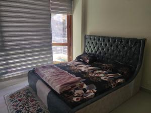 a large bed in a bedroom with a large window at Nature, Meditation with fun and Luv in Woods BAROG near KASAULI in Barog