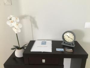 a black table with a clock and flowers on it at Cantinho do Sonho in Maia