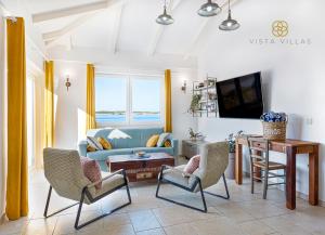 un soggiorno con divano blu e sedie di Vista Villas - Sweet Life Apartment Villa S a Ražanac (Rasanze)