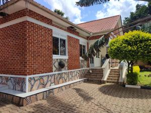 a brick house with a staircase in front of it at HEDGE GUEST HOUSE in Kampala