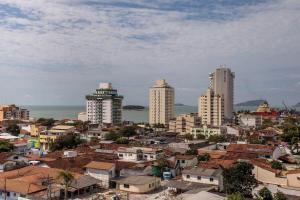 uma cidade com edifícios altos e o oceano em Flat 804 - Conforto, praticidade e vista panorâmica em Macaé em Macaé