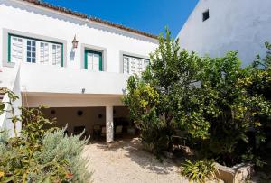 una casa blanca con árboles delante de ella en Casa da Paz en Labrugeira