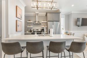 a kitchen with a large white island with six chairs at The Palm Suite at 124 Spring in Charleston