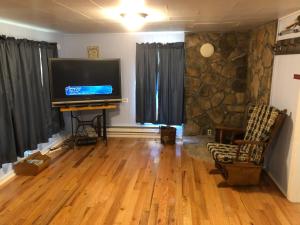 a living room with a large flat screen tv at Cochran Farm House in Bryson City
