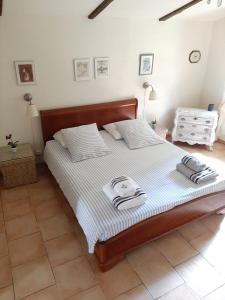 ein Schlafzimmer mit einem Bett mit zwei Handtüchern darauf in der Unterkunft Les Deux Magnolias in Saint-Léon-sur-lʼIsle