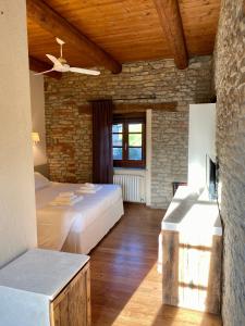 1 dormitorio con 2 camas y pared de piedra en I Tre Poggi Dimora di Charme, en Canelli