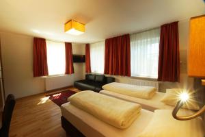 a living room with two beds and a couch at Gasthof zur Post in Strasswalchen