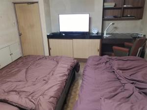 a bedroom with a bed and a tv on a desk at Condominium Tsuwanosou - Vacation STAY 67529v in Tsuwano