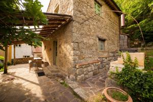 una casa de piedra con un patio frente a ella en Podere Tepolino, en Castel del Piano