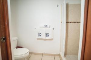 a bathroom with a toilet and a shower with a towel at Hotel Meson de Mita in Punta Mita