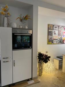 einen weißen Schrank mit einem TV im Wohnzimmer in der Unterkunft ZEITLOS in Velden in Velden am Wörthersee