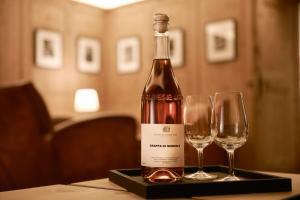 a bottle of wine and two wine glasses on a table at Pensiun Aldier in Sent