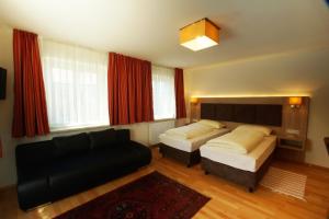 a living room with two beds and a couch at Gasthof zur Post in Strasswalchen