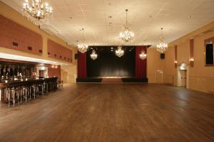 une pièce vide avec une scène et un grand hall dans l'établissement Hotel Restaurant Riche, à Boxmeer