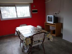 Habitación con mesa con sillas y TV. en Casa Centrica Lujan Planta Alta en Luján