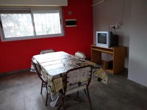 a room with a table with chairs and a tv at Casa Centrica Lujan Planta Alta in Luján