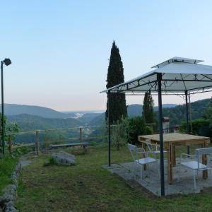 a table and chairs under an umbrella in a field at Villa Margherita in Anduins