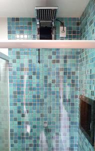 a blue tiled bathroom with a blue tile wall at Chalé Sienna Ar condicionado Pousada 35knots Brasil in Luis Correia