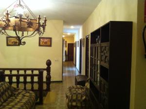 sala de estar con sofá y lámpara de araña en Hostal Paracuellos en Paracuellos de Jarama