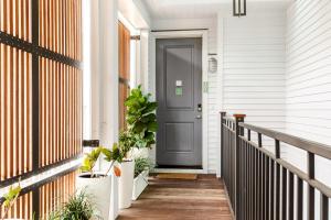 a porch with a gray door and potted plants at The Santee Suite at 122 Spring in Charleston