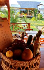 a basket of fruit and vegetables on a table at Chalé Vera Ar condicionado Pousada 35knots Brasil in Luis Correia