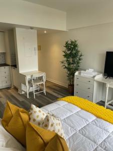 a bedroom with a bed and a table and a kitchen at Faubourg Ste Cath in Montreal