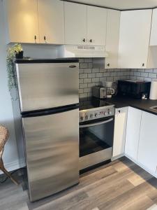 a kitchen with a stainless steel refrigerator and a stove at Faubourg Ste Cath in Montréal