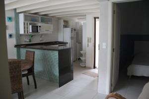 a kitchen with a counter and a dining room at Casa- Maresias 3 minutos da praia in Maresias