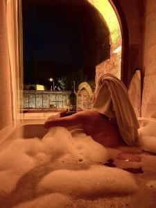 a person laying in a bath tub covered in snow at Angel Cave Suite in Göreme