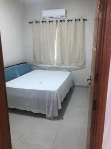 a small bedroom with a bed and a window at Casa Siqueira Nova Viçosa in Nova Viçosa
