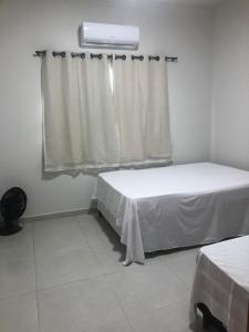 a small room with two beds and a window at Casa Siqueira Nova Viçosa in Nova Viçosa +12 photos